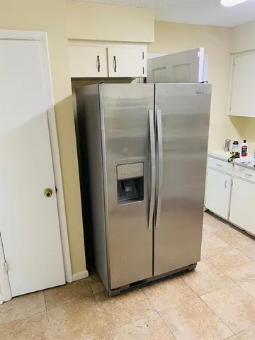 a metallic refrigerator freezer sitting in a kitchen