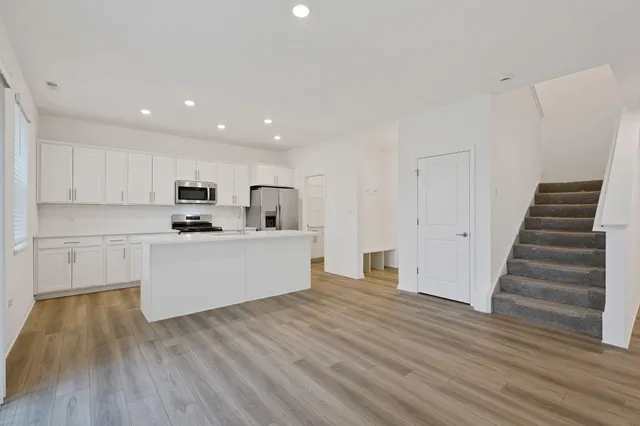a view of kitchen with wooden floor and electronic appliances