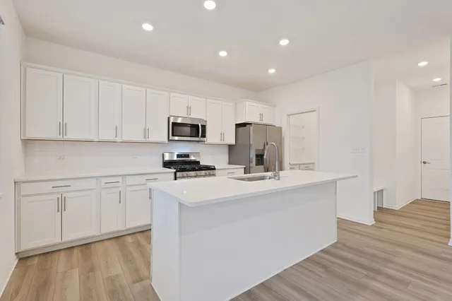 a kitchen with stainless steel appliances a refrigerator sink and microwave