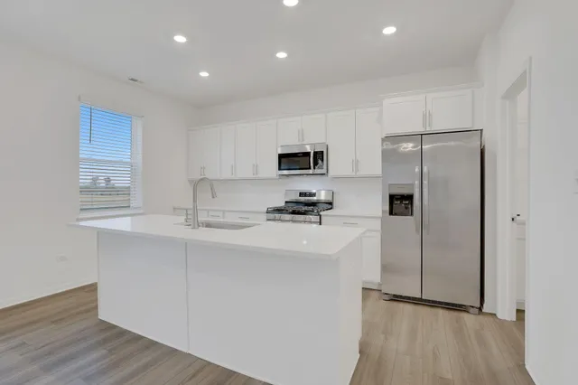 a kitchen with a refrigerator a sink and a microwave