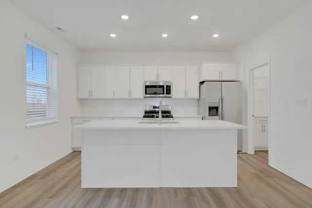 a view of kitchen with stainless steel appliances granite countertop refrigerator sink and stove