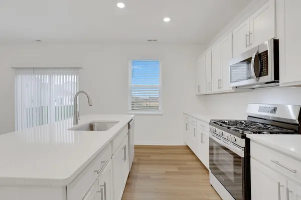 a kitchen with stainless steel appliances granite countertop a sink stove and cabinets