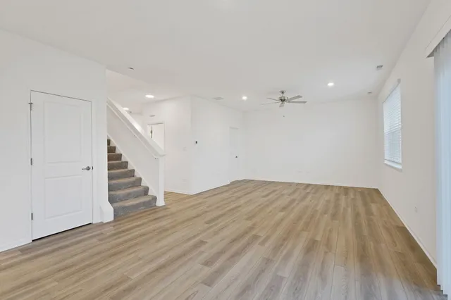 an empty room with wooden floor and staircase