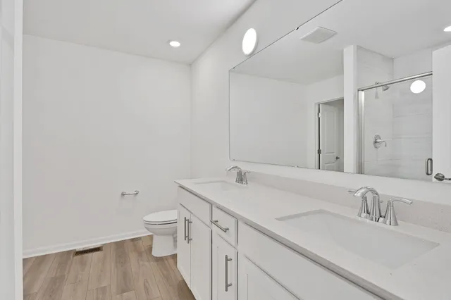 a bathroom with a sink a toilet and a large mirror