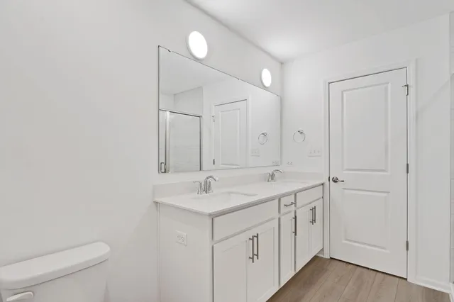 a view of a bathroom with 2 sink toilet and a mirror