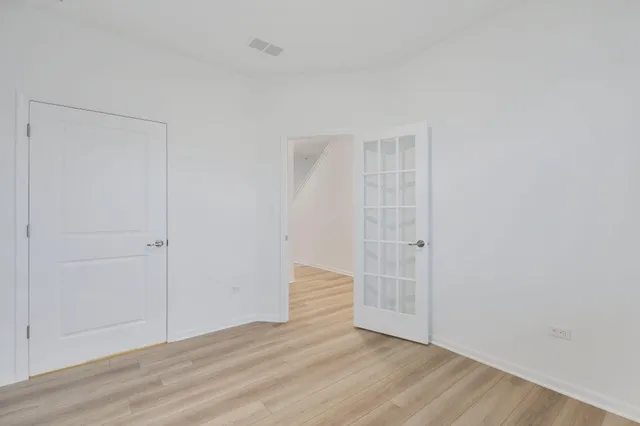 a view of an empty room with wooden floor