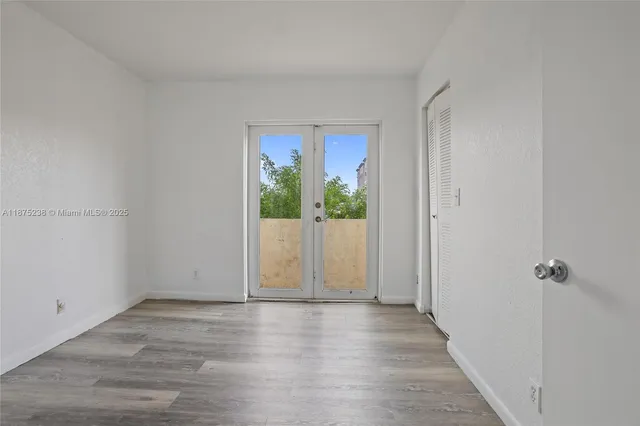 a view of a hallway with wooden floor and closet