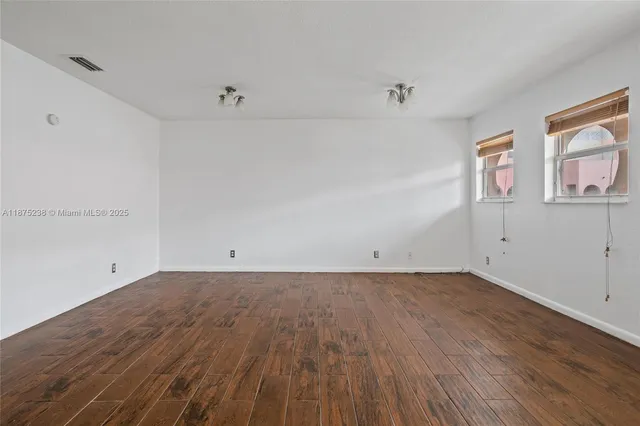 a view of a room with wooden floor and window