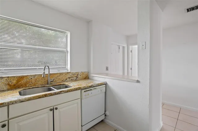 a bathroom with a granite countertop sink and a window