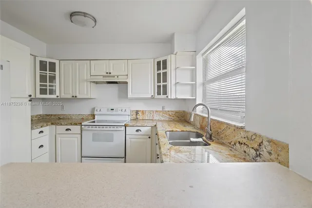 a kitchen with stainless steel appliances granite countertop a sink and a stove