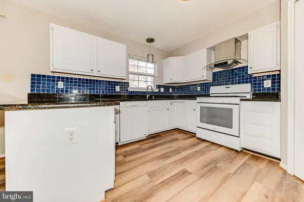 a kitchen with granite countertop a sink and cabinets