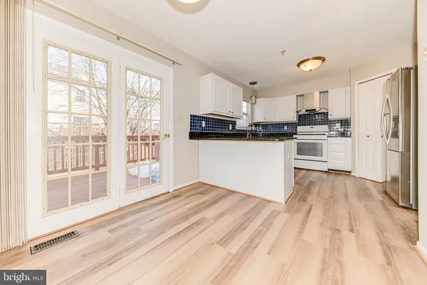 a kitchen with granite countertop a refrigerator stove top oven and sink