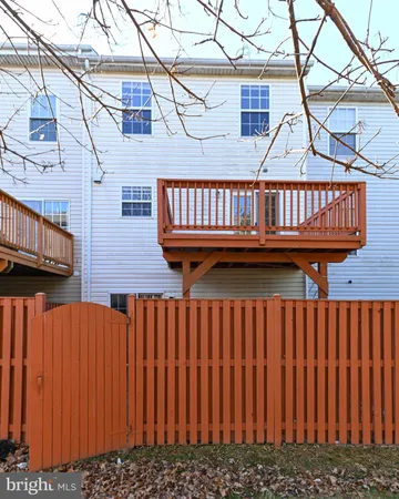 a view of a deck with wooden fence and a bench