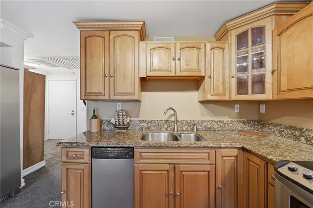 a kitchen with stainless steel appliances granite countertop a sink stove and cabinets