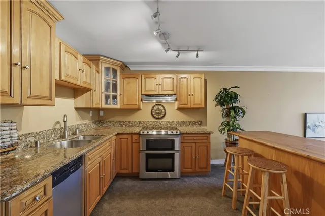 a kitchen with stainless steel appliances granite countertop a sink stove and cabinets