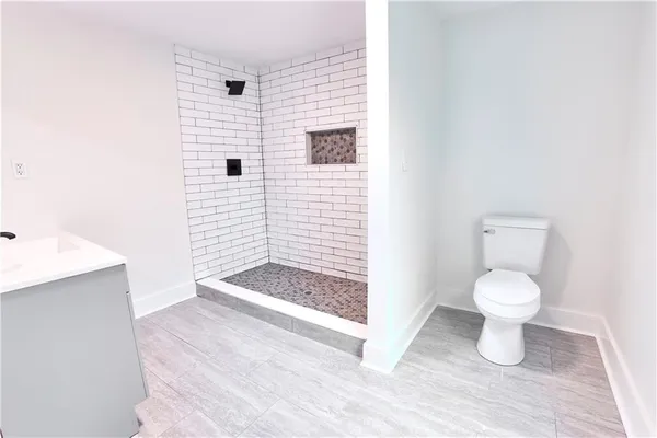 a bathroom with a toilet and a shower
