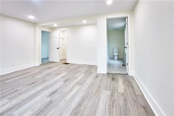 an empty room with wooden floor and a toilet