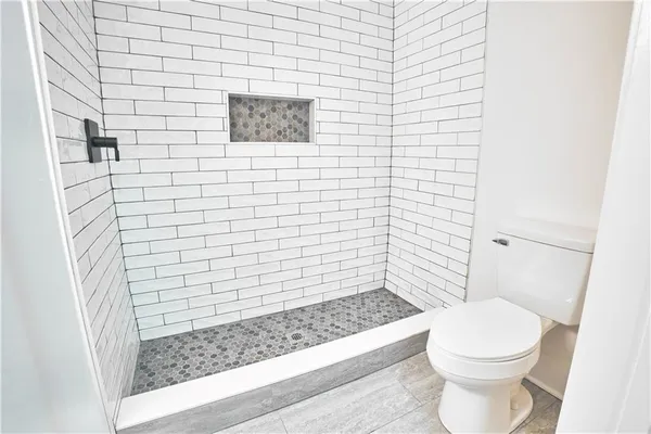 a bathroom with a toilet and a shower