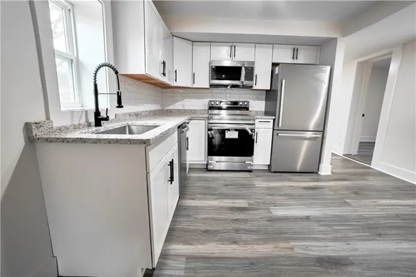 a kitchen with stainless steel appliances a refrigerator stove and a sink
