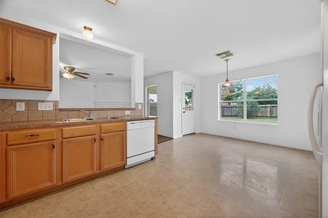 a kitchen with granite countertop white cabinets and stainless steel appliances