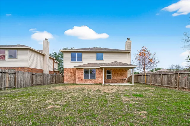 an empty room with wooden floor ceiling fan and windows