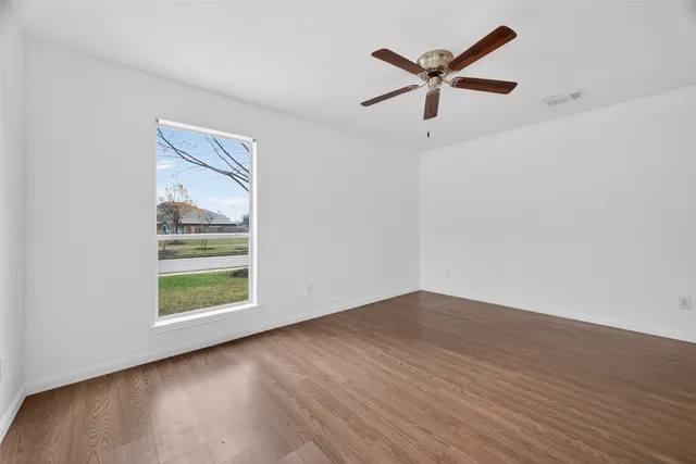 wooden floor in an empty room with a window