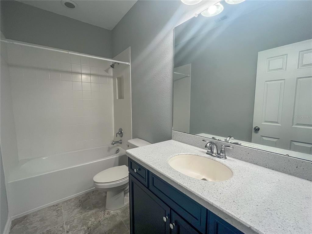 26391 Limestone Springs Way Wesley Chapel, FL 33544 - Photo 14 of 16 a bathroom with a granite countertop sink toilet and shower