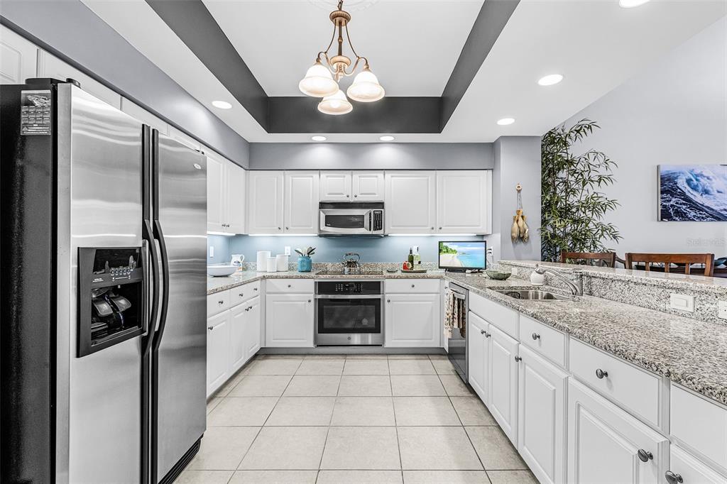 3333 Sunset Key Circle, Unit 103 Punta Gorda, FL 33955 - Photo 20 of 58 a large kitchen with stainless steel appliances granite countertop a stove sink and refrigerator