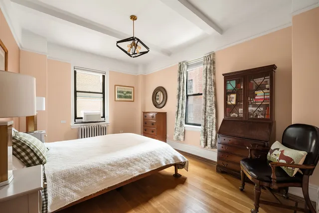 a bedroom with a bed a dresser and chair