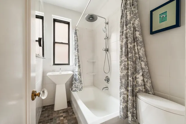a bathroom with a shower curtain and a toilet