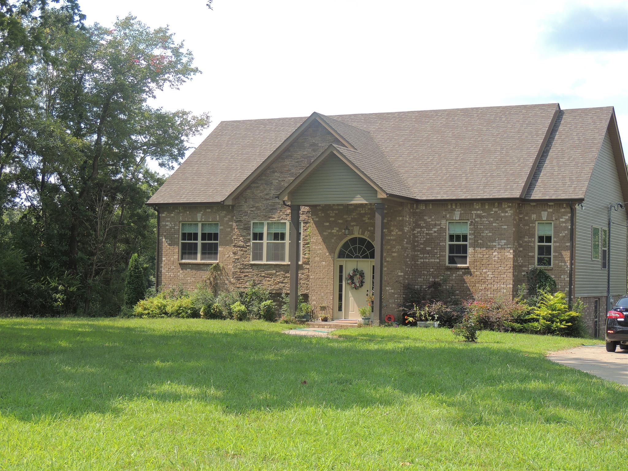 3172 Marthas Chapel Road Cunningham, TN 37052 - Photo 3 of 29 a front view of a house with a yard and garden