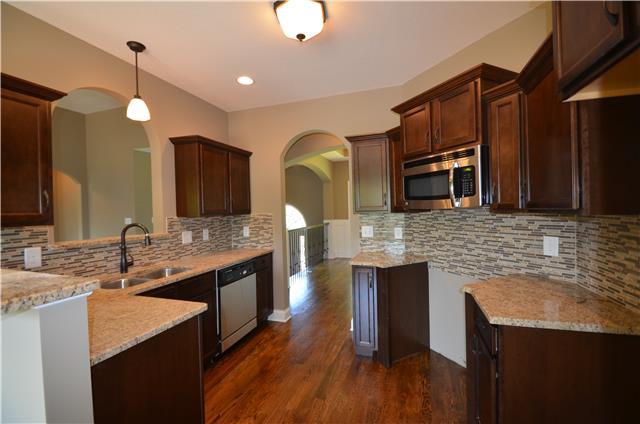 3172 Marthas Chapel Road Cunningham, TN 37052 - Photo 10 of 29 a kitchen with stainless steel appliances granite countertop a sink and wooden cabinets