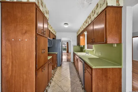a kitchen with stainless steel appliances granite countertop a sink and a refrigerator