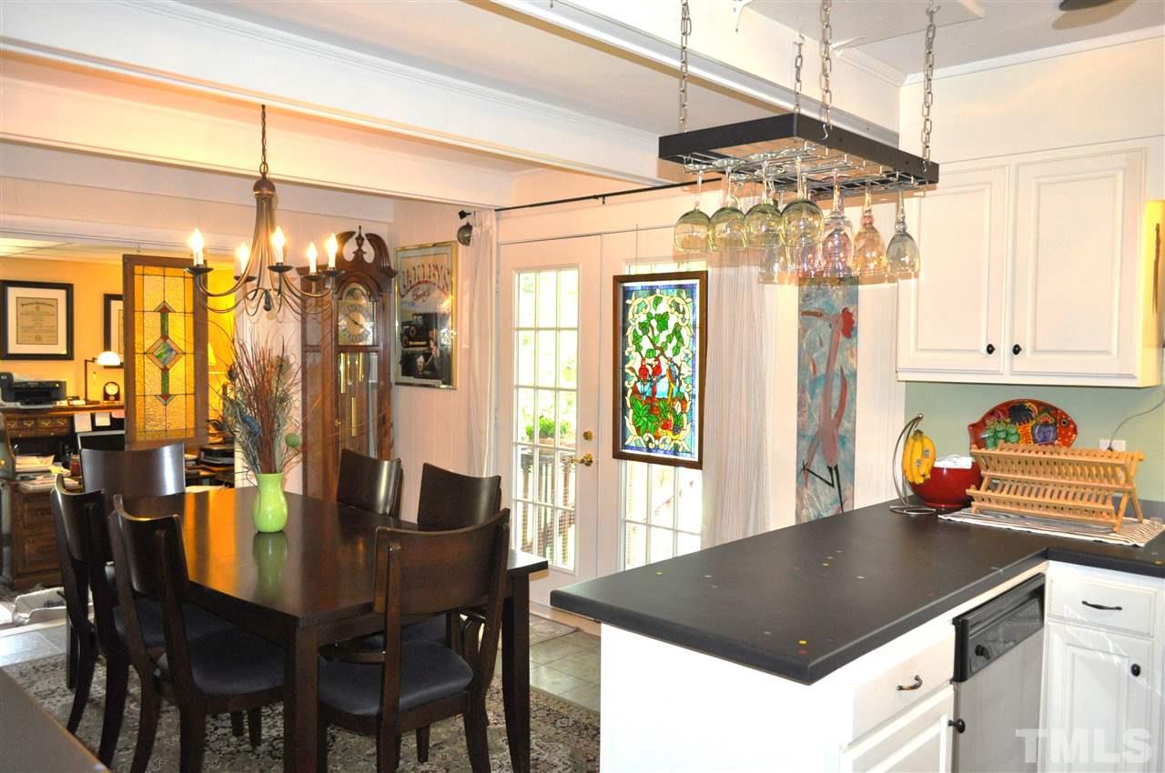 4908 Auburn Road Raleigh, NC 27609 - Photo 11 of 25 a kitchen with a table chairs and white cabinets