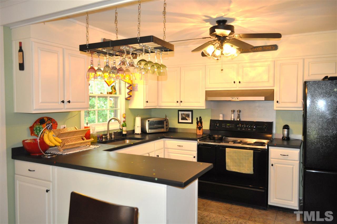4908 Auburn Road Raleigh, NC 27609 - Photo 14 of 25 a kitchen with a stove a sink and a refrigerator