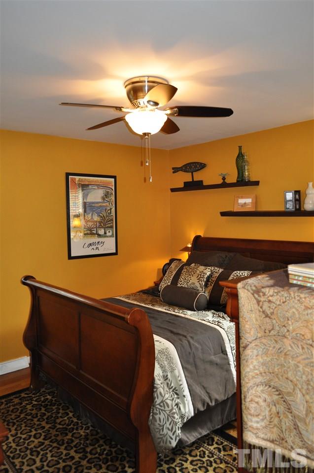 4908 Auburn Road Raleigh, NC 27609 - Photo 17 of 25 a bedroom with a bed and ceiling fan