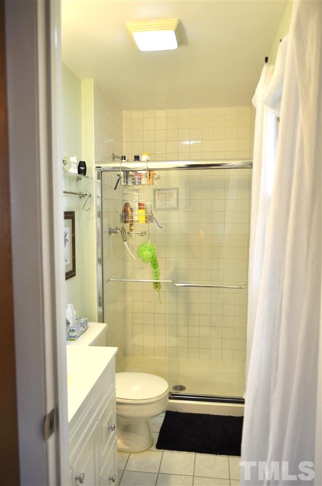 4908 Auburn Road Raleigh, NC 27609 - Photo 20 of 25 a bathroom with a granite countertop shower a toilet and a shower