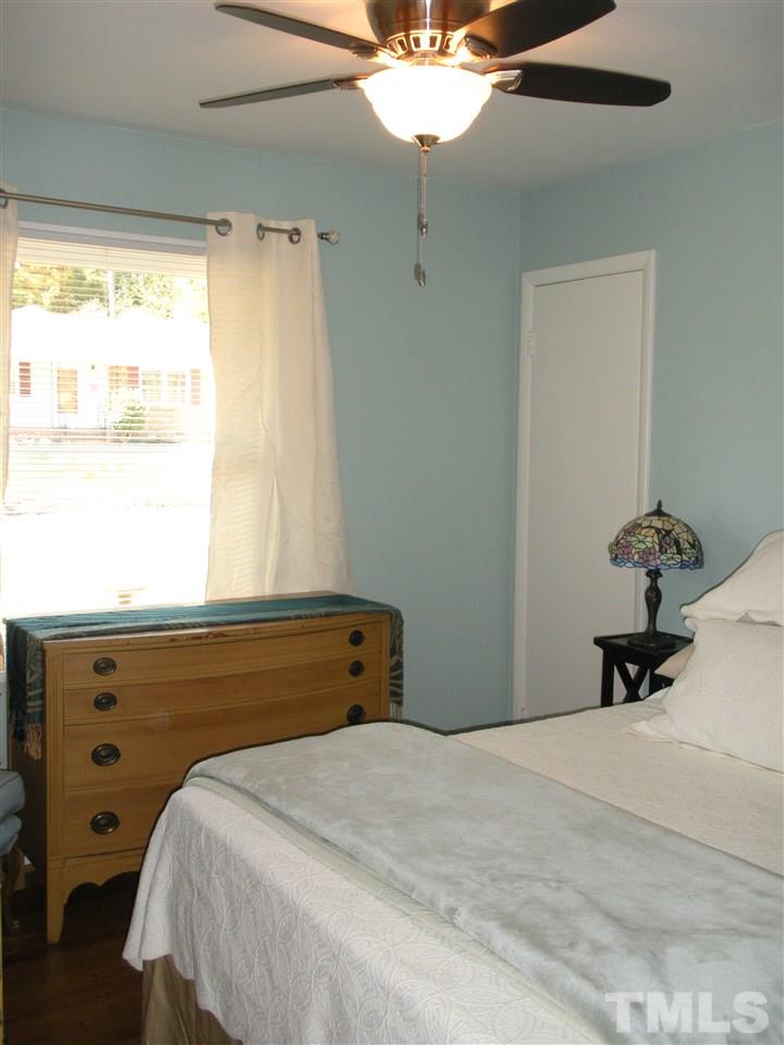 4908 Auburn Road Raleigh, NC 27609 - Photo 23 of 25 a bedroom with a bed and a chandelier