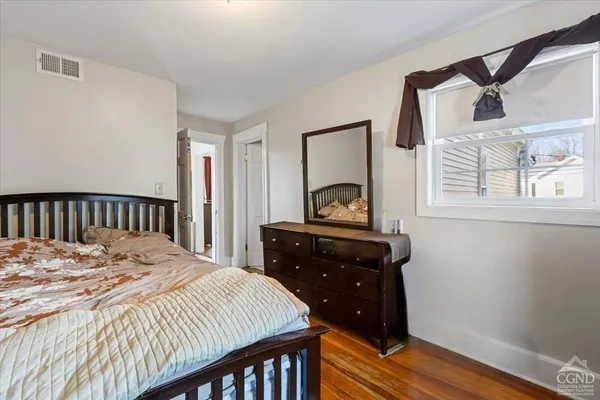 a bedroom with a bed and wooden floor