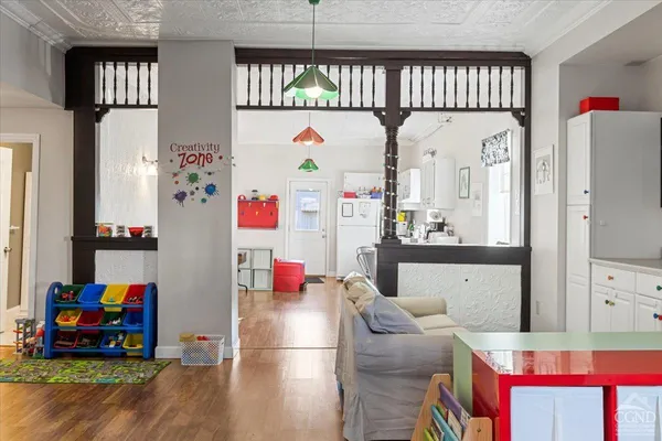 a room with furniture a rug toys and a window