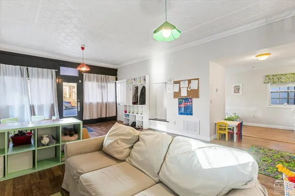 a living room with furniture and a wooden floor