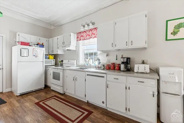 a kitchen with white cabinets and white appliances