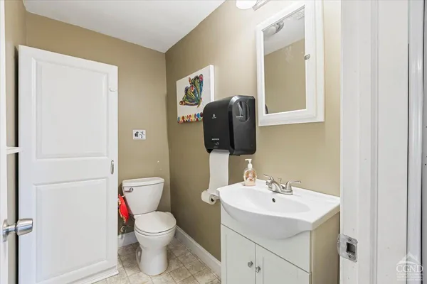 a bathroom with a toilet sink and mirror