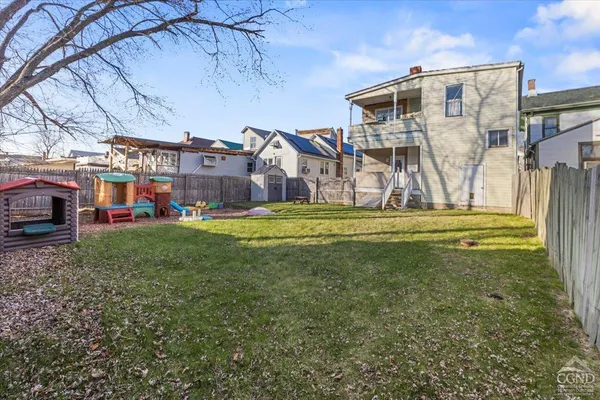 a view of a big house with a big yard and large trees