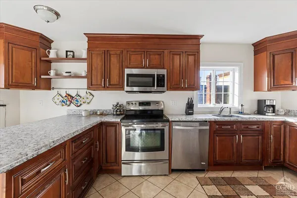 a kitchen with stainless steel appliances granite countertop a stove microwave and sink