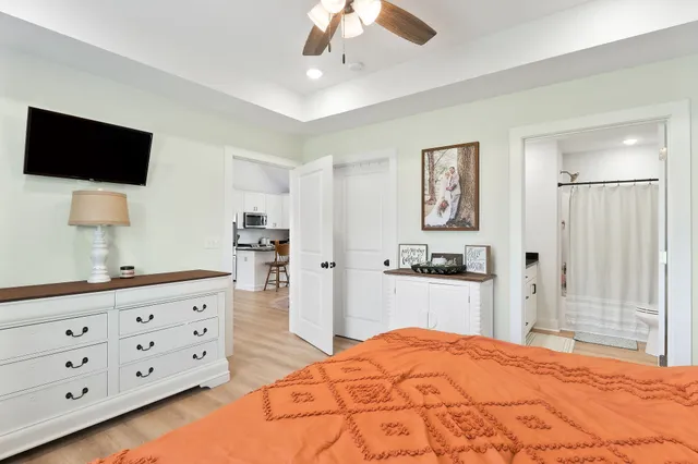 a large bedroom with a bed and a flat tv screen on dresser