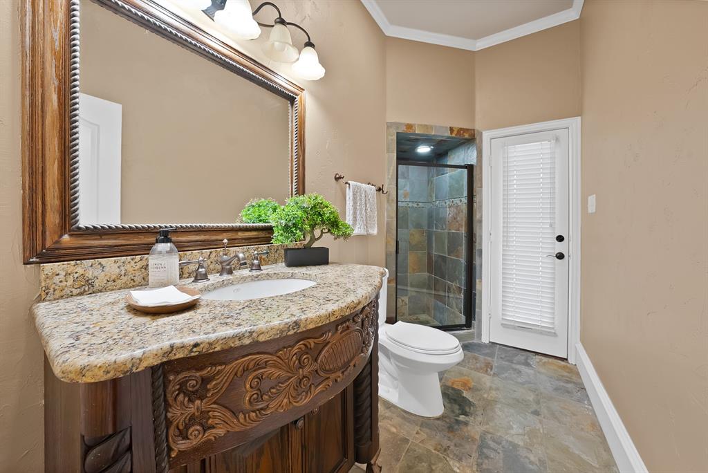 1110 McCampbell Road Mansfield, TX 76063 - Photo 30 of 39 a bathroom with a granite countertop sink a toilet a mirror and shower