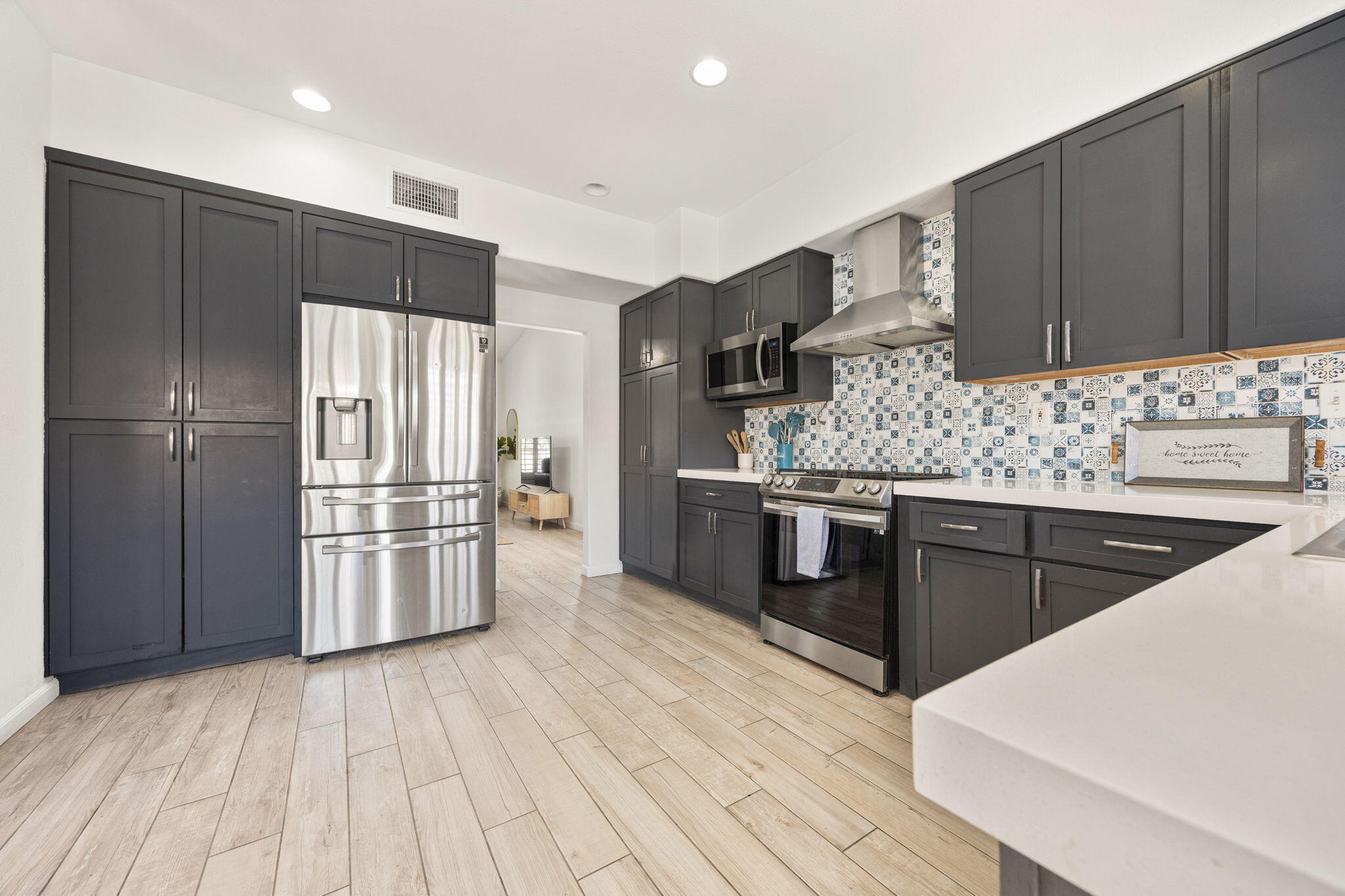 a kitchen with stainless steel appliances kitchen island granite countertop a refrigerator and a stove top oven