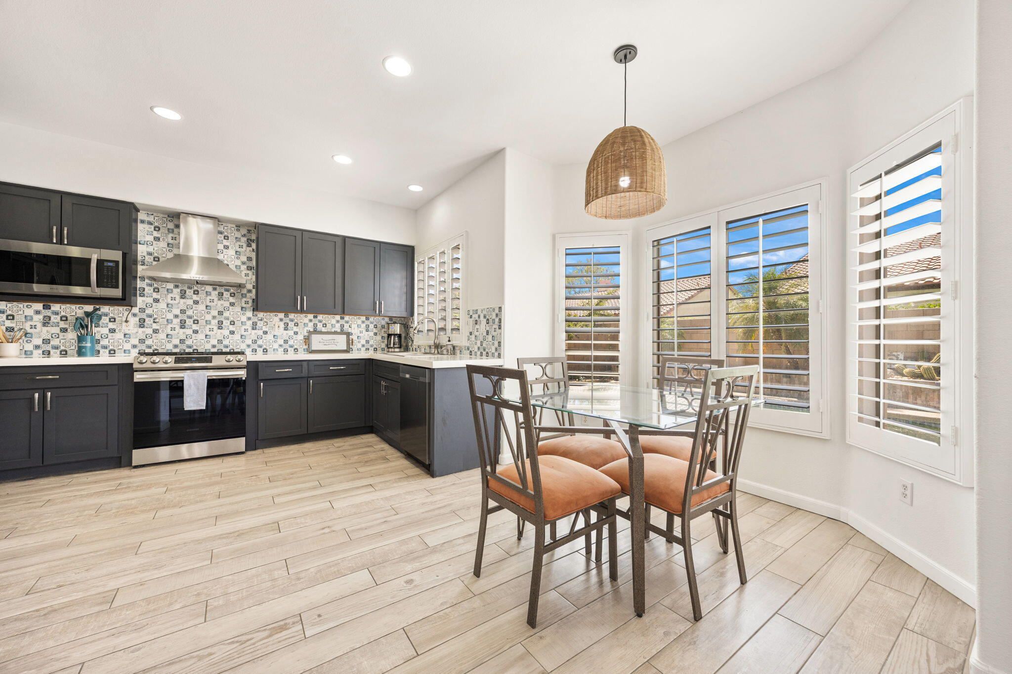 48701 Gibraltar Street Indio, CA 92201 - Photo 5 of 52 a kitchen with stainless steel appliances granite countertop a stove top oven a dining table and chairs