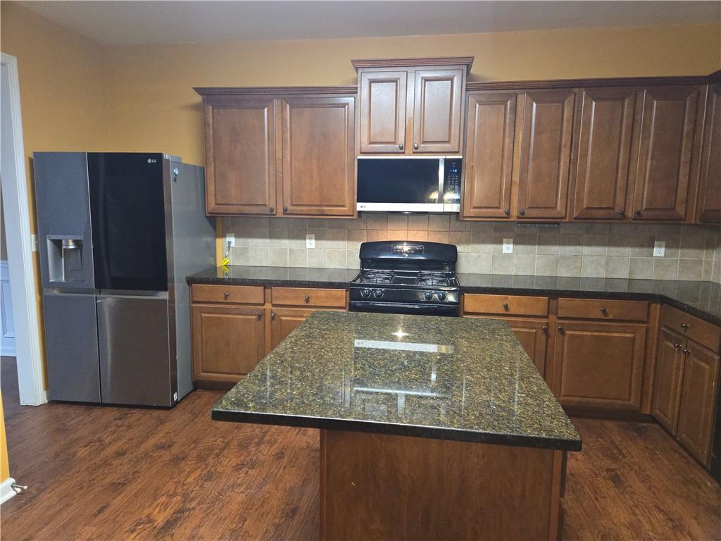 4613 Irish Red Court Union City, GA 30291 - Photo 5 of 15 a kitchen with granite countertop wooden cabinets a refrigerator and a sink